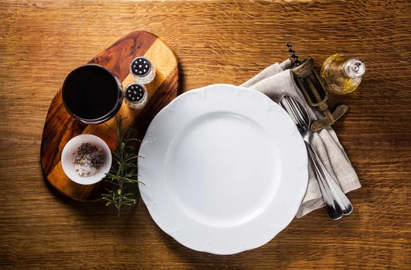 En tom plåt på ett träbord och ett glas rött vin. Servin — Stockfoto