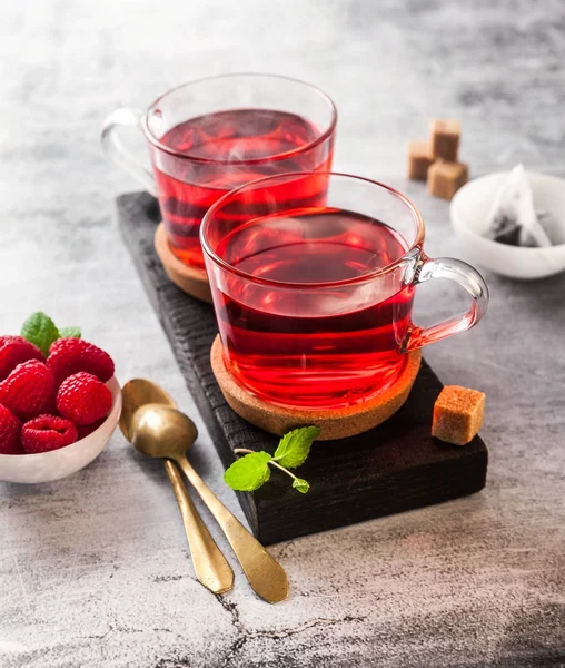 hot raspberry tea in two transparent cups on a stone table. Fres