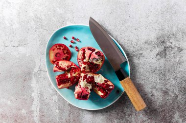 Olgun kırmızı nar taş bir tablo bir tabağa kesti. h meyvesi