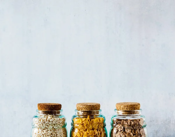 Variety of cold quick breakfast cereals in glass jars , healthy
