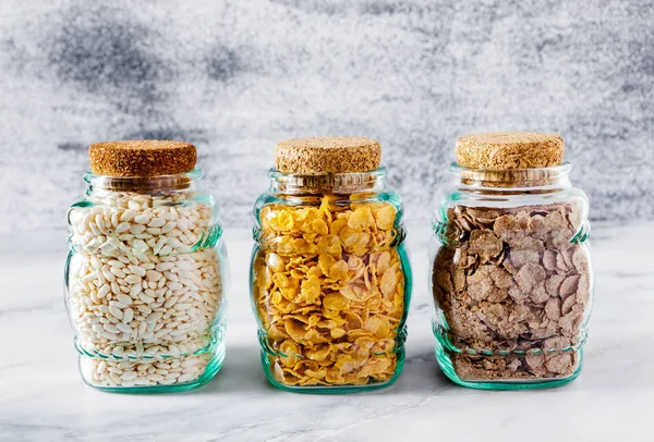 Variety of cold quick breakfast cereals in glass jars , healthy