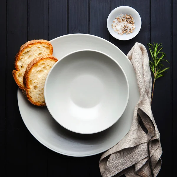 Sirviendo sopa. Platos vacíos y pan. sobre un fondo oscuro. Clea. — Foto de Stock