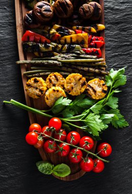 siyah mazisi bir ahşap tepsi üzerinde ızgara sebze. kopya alanı