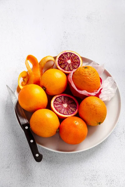 Grupa pomarańcze na talerzu. Niektóre z nich wyciąć. nóż. na st — Zdjęcie stockowe