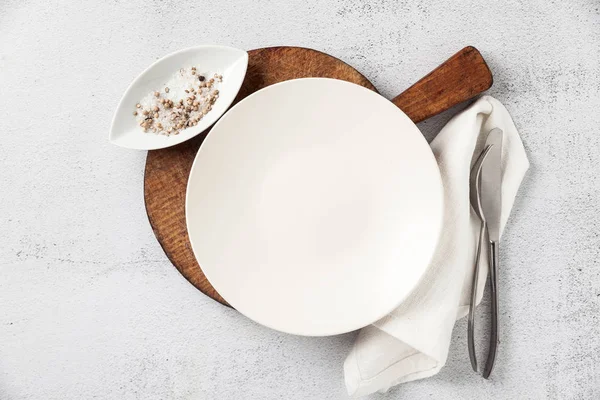 Пустая тарелка и столовые приборы на деревянной доске. вилка, нож — стоковое фото