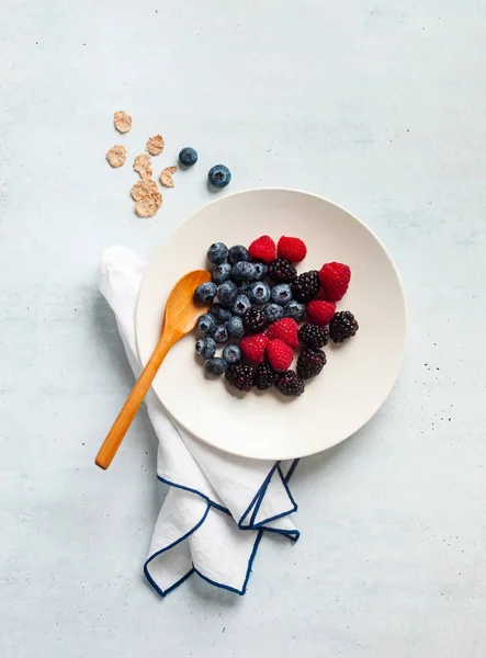 Breakfast with berries, yogurt, flakes and cut papaya in a plate — Stock Photo, Image