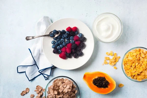 Café da manhã com bagas, iogurte, flocos e mamão de redução em uma chapa — Fotografia de Stock