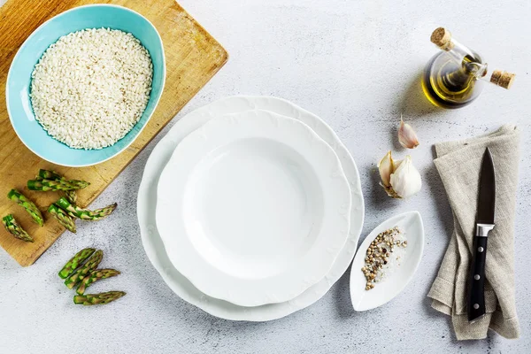 Пустая белая тарелка и ингредиенты на белый кухонный стол. копия — стоковое фото