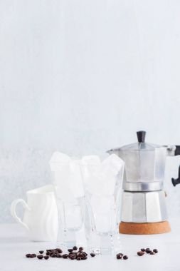 masada buz iki boş bardak. ve bir kahve makinesi