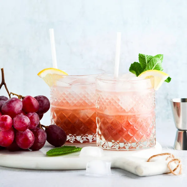 Coquetel alcoólico rosa de uvas maduras frescas em uma coqueteleira com ic — Fotografia de Stock
