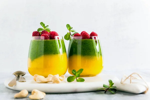 Fresh vegan layered dessert in a glass of colored smoothies of m