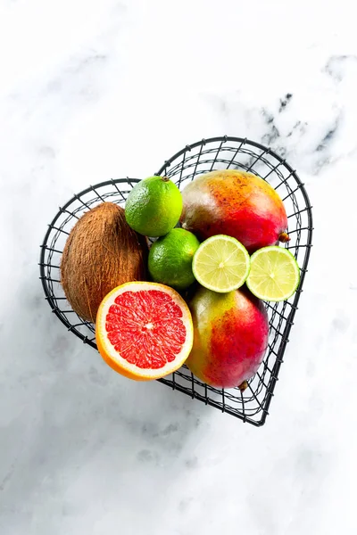 Frutas exóticas em um cesto na forma de um coração. foto de um — Fotografia de Stock
