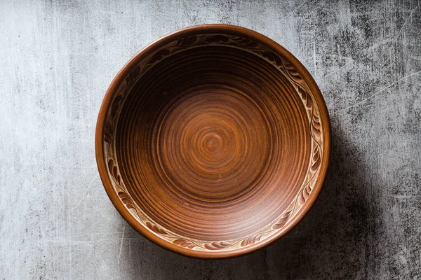 Empty clay plate and chopsticks on a dark stone background. line — Stock Photo, Image