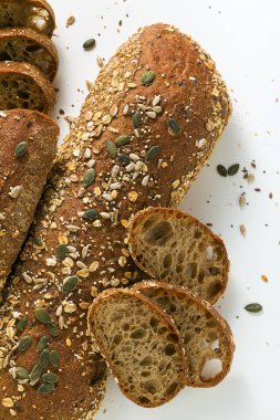Taze çavdar ekmeği beyaz bir arka planda izole edilmiş tohumlarla