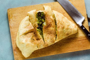 Calzone İtalyan pizzası, taze otlar ve otlarla birlikte. Sağlıklı yiyecekler