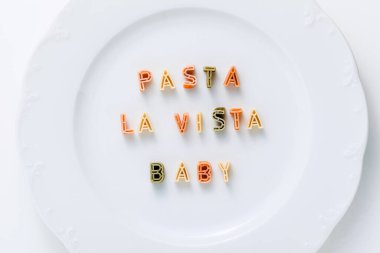 Beyaz bir tabakta çok renkli kuru makarnadan çıkan Pasta LA VİASTA.