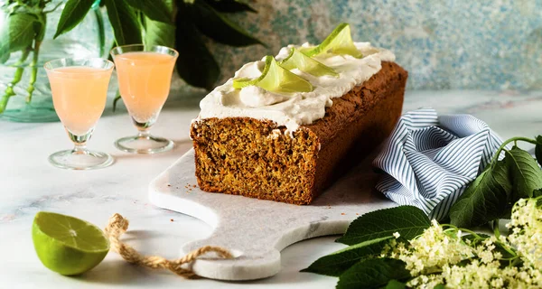 banner of summer sweet loaf cake on a table with flowers and a drink in glasses. with coconut cream and lime. dessert for brunch or morning breakfast