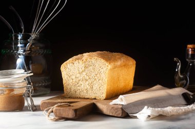 Taze ev yapımı tost ekmeği mutfak masasında, koyu arkaplanda..