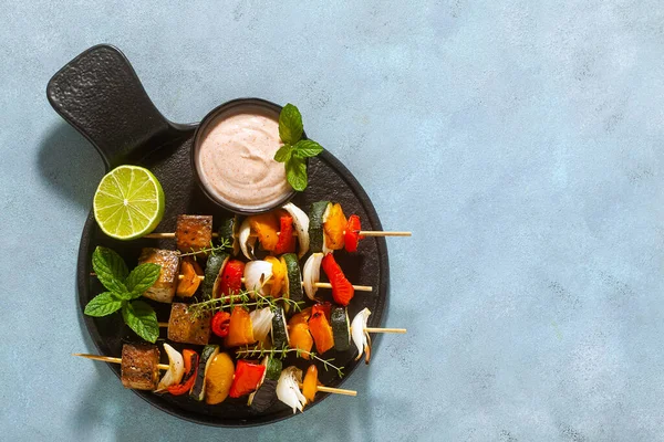 野菜のビーガンケバブとキャッシュソースとスモークパプリカのスモーク豆腐を青い背景に — ストック写真