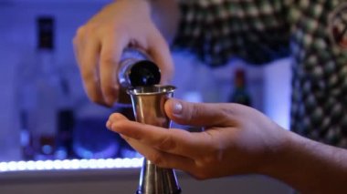 Barmen alkollü kokteyl hazırlar. Yavaş yavaş dökerek alkol.