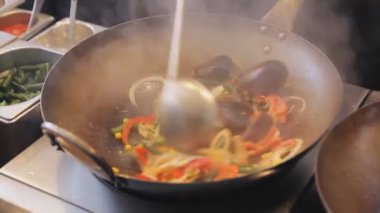 Profesyonel aşçı midye ve karides sebze sokak gıda Festivali ile kızartma. Kızarmış karides ve yumuşakça kapatın. Süreç Denizi'nin yemek yemek. Geleneksel Asya gıda.