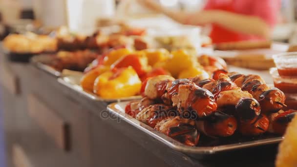 Mucha comida en el festival de comida callejera. Comida sabrosa a la parrilla en sartenes. Barbacoa de carne y verduras, tomates, pimentón . — Vídeos de Stock