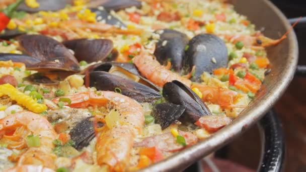 Paella espanhola com arroz amarelo, camarões e mexilhões cozinhando no mercado de alimentos. Festival de comida de rua. Arroz com frutos do mar fervendo de perto. Comida espanhola tradicional . — Vídeo de Stock