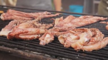 Kalamar, ahtapot, mürekkep balığı ızgarada hazırlanıyor, yakın çekim. Ahtapot Izgara dönüm. Ahtapot et mangal üzerinde kavrulmuş. Kızarmış balık ızgara. Sokak yemek Festivali.