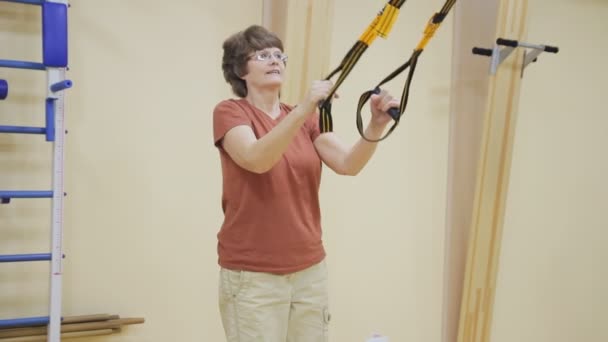 Bejaarde vrouw kraken, doen fysiotherapie oefeningen in de fitnesszaal. Gezonde Turnen. Actieve senioren. — Stockvideo