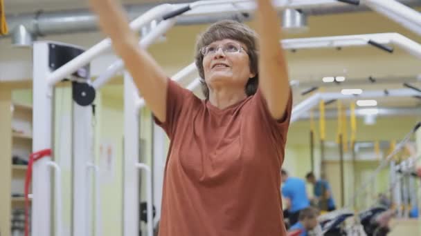 Eine ältere Frau streckt sich aus, macht Übungen im Fitnessraum. Gesundes Turnen. Aktive Senioren. — Stockvideo