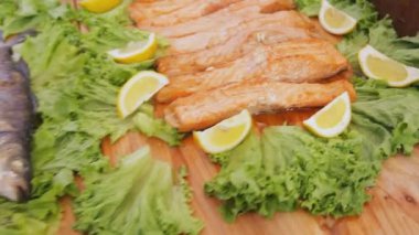 Pişmiş kırmızı somon salata ile. Yeşiller ve yemek Festivali masada üzerinde limon ile pişmiş balık fileto.