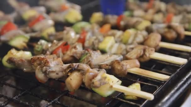 Barbecue frog legs and mushrooms on the skewers. Grilled meat and vegetables cooking at the market. A lot of grilled food. — Stock Video