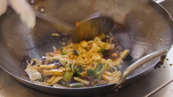 在街头美食节, 专业厨师用豆腐和面条煎蔬菜。烹调接近的过程. — 图库视频影像