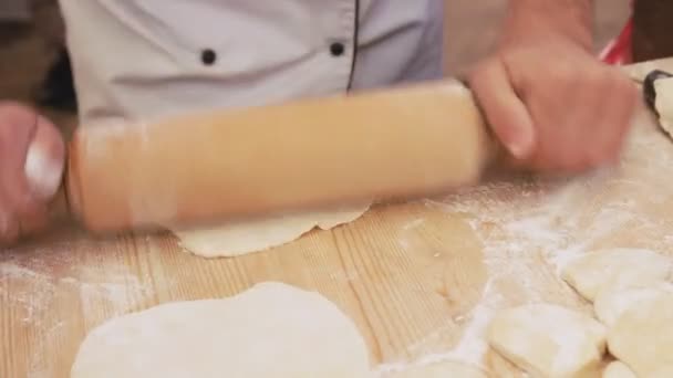 Pâte à pétrir Baker avec rouleau à pâtisserie sur la table. Gros plan sur les mains faisant de la pizza . — Video