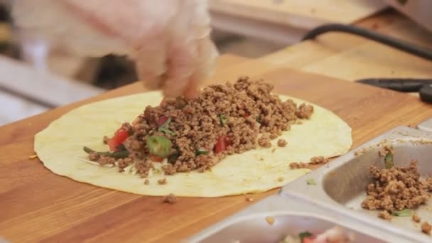 Profesionální kuchař dělá taco s pita a zeleninou na street food festivalu. Proces vaření zavřít. — Stock video
