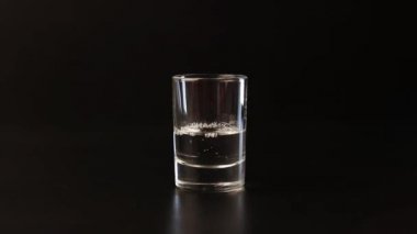 Erkek el alkol cam içine dökme. Barmen alkollü kokteyl atış hazırlanıyor.