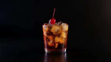 Bir el kiraz ile alkollü bir kokteyl içki alır.