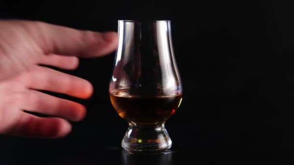 Uma mão toma uma bebida de álcool de vidro e do que o põe atrás . — Vídeo de Stock