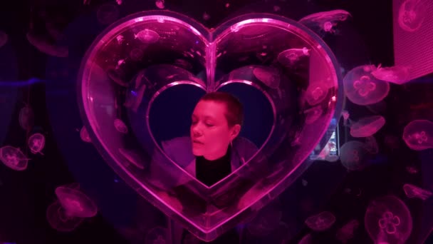 Woman inside abstract heart aquarium made of jellyfish. Pink Moon Jellyfish or Aurelia Aurita or Saucer Jelly. Valentines day concept. — Stock Video