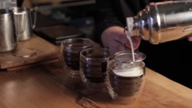Barista İrlanda kahvesi yapıyor. Bir fincan kahveye krema döküyorum..
