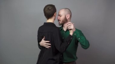 Romantic couple dancing on gray background. Man and woman are dancing slow blues dance. Sensual couple dancing.