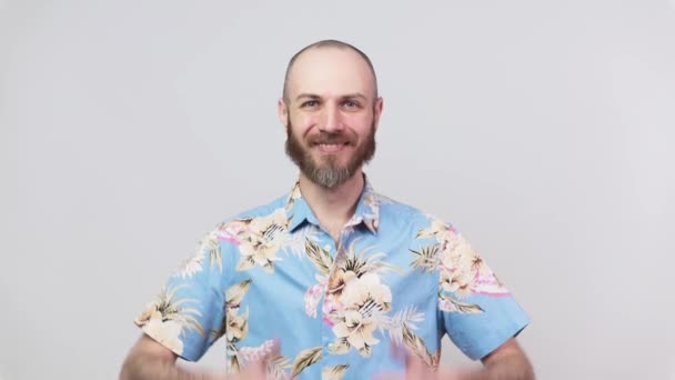 Feliz hombre barbudo con camisa hawaiana mostrando pulgares arriba sobre fondo blanco. Buen trabajo, muy bien. . — Vídeo de stock