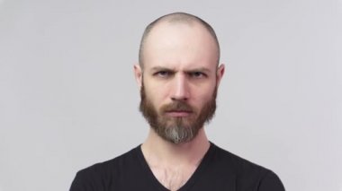 Katı adam beyaz arka plan üzerinde uyarı işareti yapmak için parmağını kaldırıyor. Ciddi derecede hoşnutsuz bir adam uyarıda bulunuyor, onaylamıyor, hayır diyor..