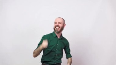 Başarılı bir adamın zaferi kutlamasına ve beyaz arka planda sıkılmış yumruğunu havaya kaldırmasına az kaldı. Başarı, zafer, zafer, kazanma ve kutlama duyguları.