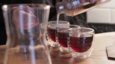 Barista İrlanda kahvesi yapıyor. Kahve fincanlarına krema döküyorum..