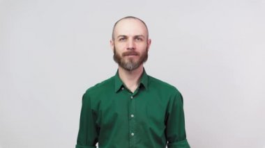 Beyaz arka planda izole edilmiş kameraya bakan sakallı adamın portresi. Duyguların kavramı.