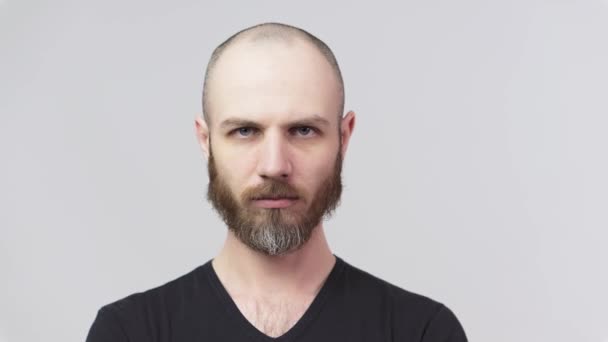 一个满脸胡须的男人盯着一架白色背景的相机 非常不满意的人情绪的概念 — 图库视频影像