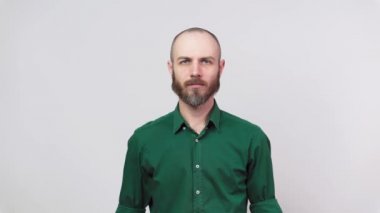 Reddetme hareketi yapan bir adam hayır, başını ve parmağını sallıyor. Ciddi sakallı adam, parmağı beyaz arka planda izole bir şekilde hareket ediyor..