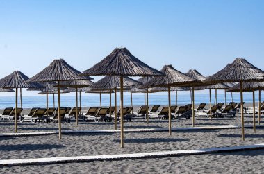 beach chairs and umbrellas, sand and ocean, blue sky