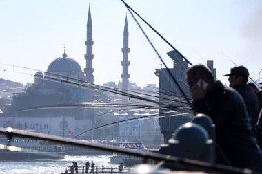 İstanbul, Türkiye - 18 Şubat 2021: Galata Köprüsü 'nde insanlar balık tutuyor.